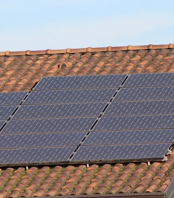 Panneaux solaires installés sur un toit en tuiles, vus en contre-plongée
